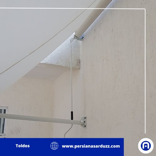 toldo color blanco de punto fijo que sirve para dar sombra a macetas de un jardín